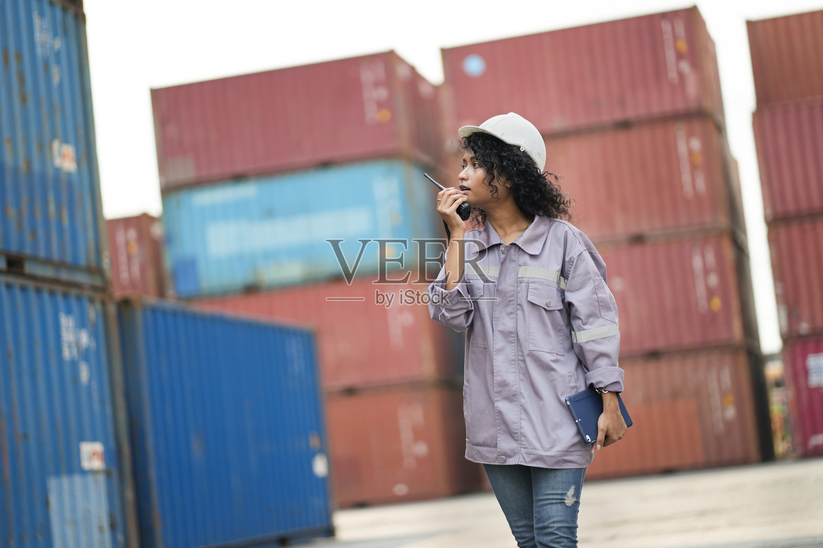 亚洲女工在集装箱场地使用对讲机检查集装箱照片摄影图片