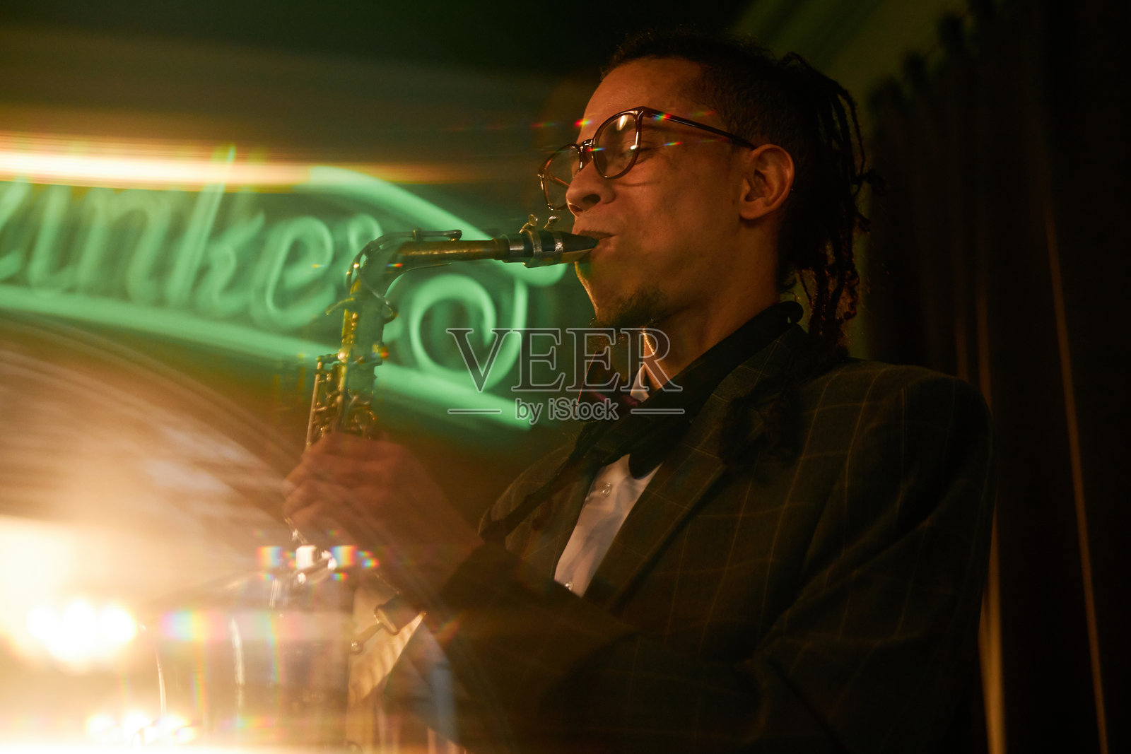 男性音乐家在酒吧即兴演奏萨克斯ophone，演奏爵士乐现场音乐照片摄影图片