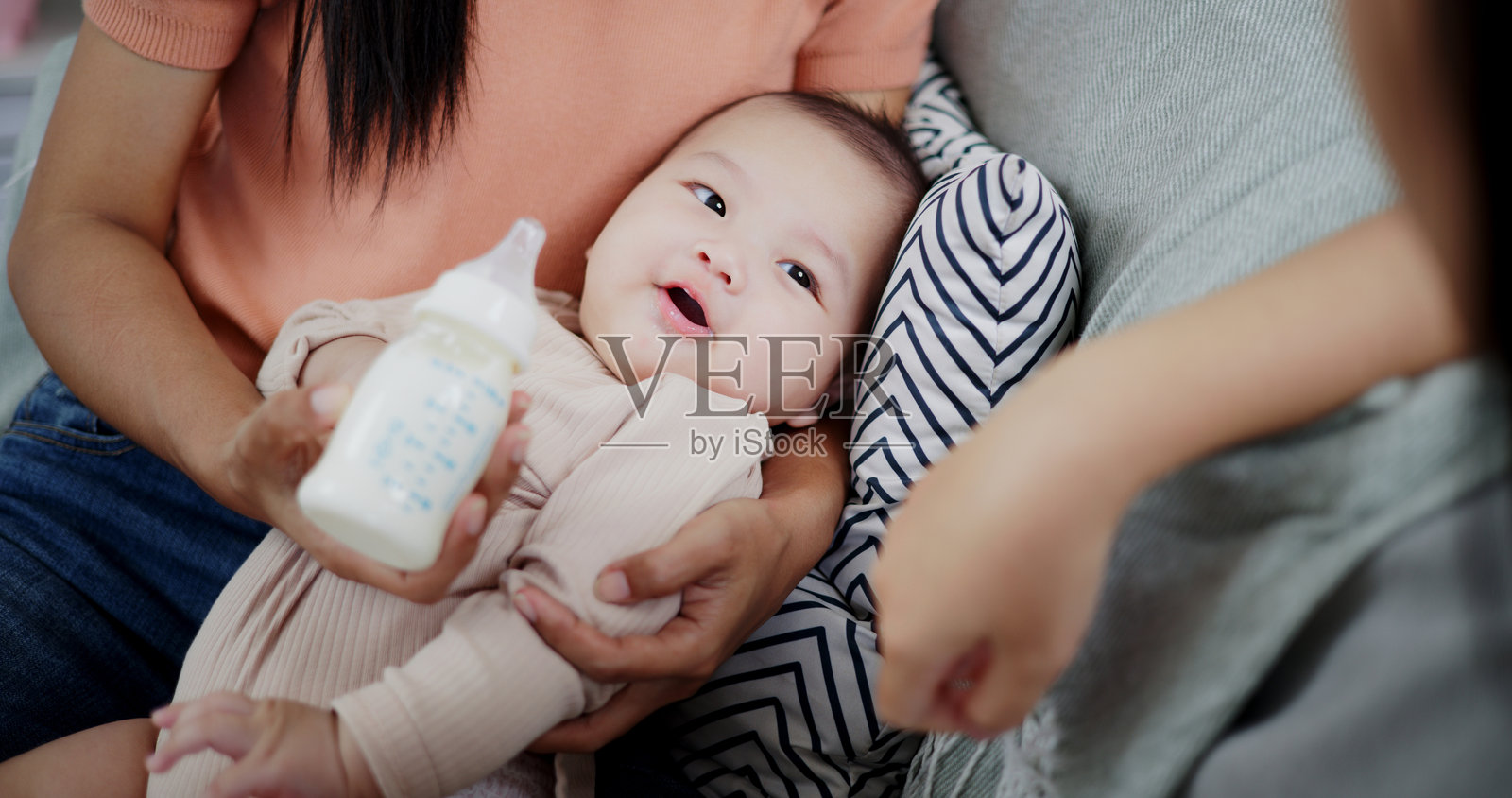 两位女性在家里的客厅沙发上快乐地和一个小男孩玩耍。照片摄影图片
