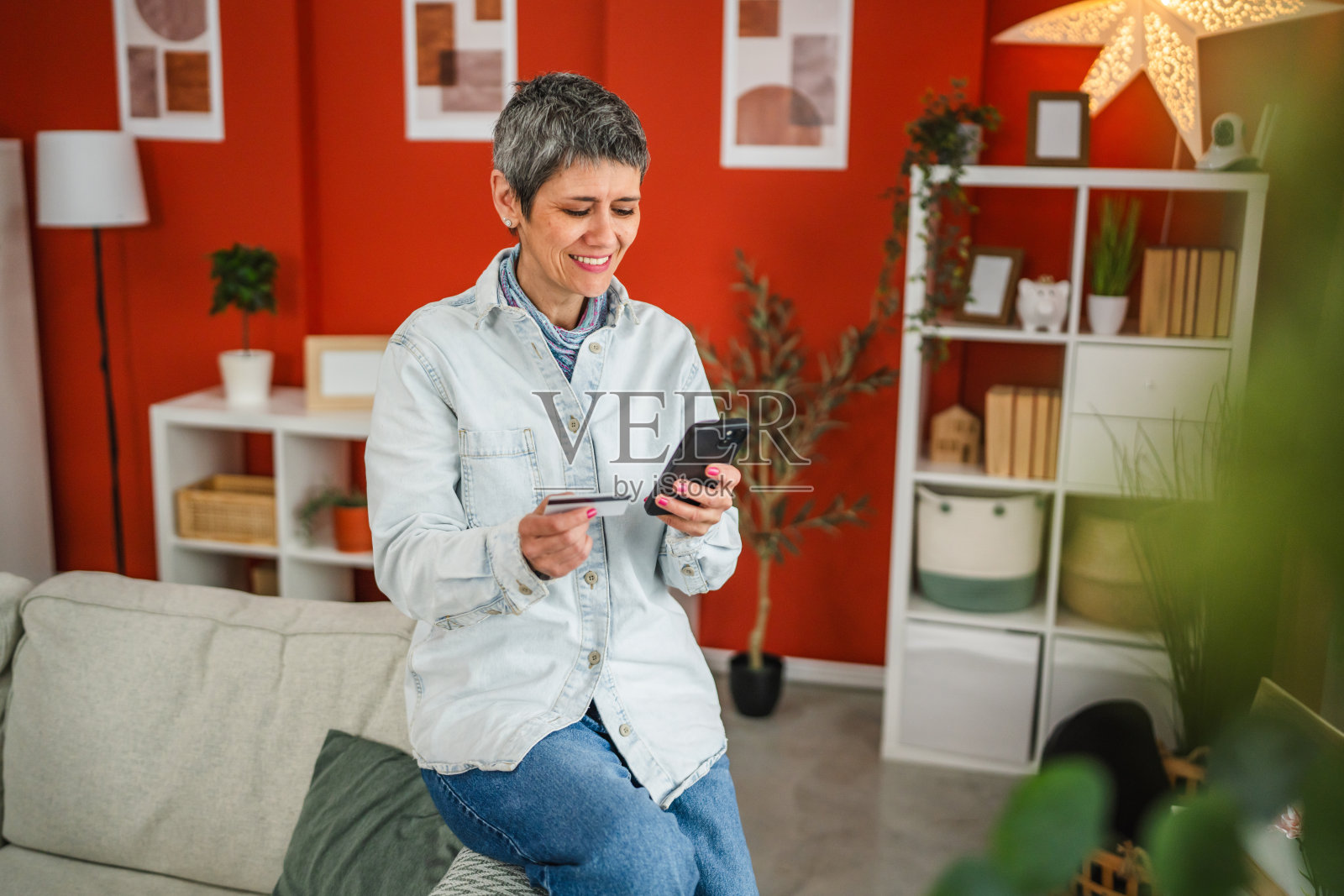 成熟的女性使用手机和信用卡进行在线购物照片摄影图片