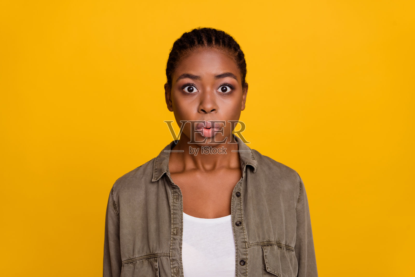 一位悲伤的千禧世代棕发女士穿着灰色衬衫，面对镜头，背景为黄色。照片摄影图片