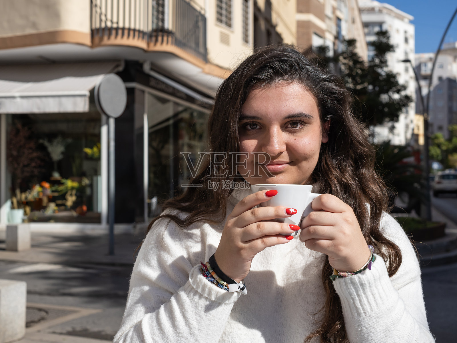 年轻女性在城市户外享受一杯咖啡照片摄影图片