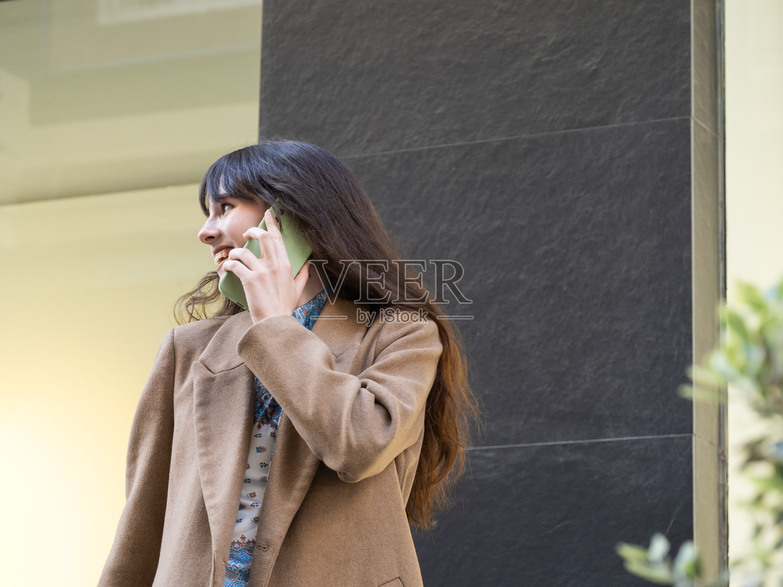 年轻女性在城市中走路时打电话照片摄影图片