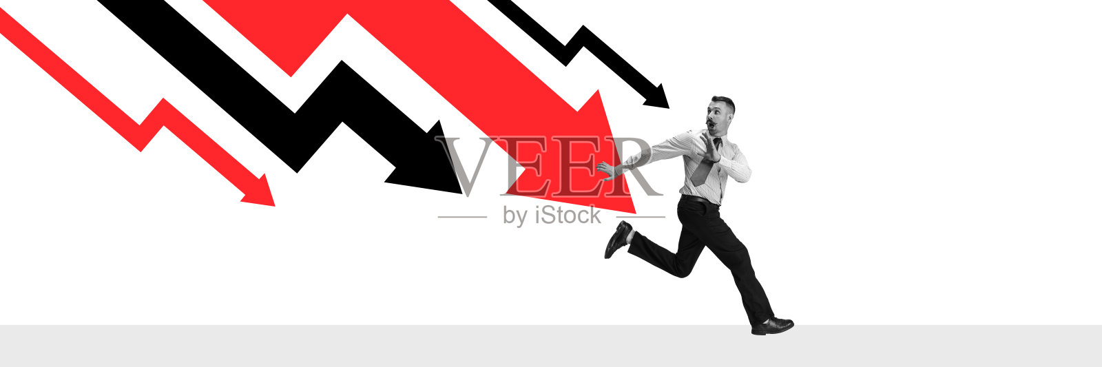 横幅。概念艺术拼贴。商人惊慌失措地逃离巨大的红色箭头，象征着对经济衰退的恐惧。照片摄影图片