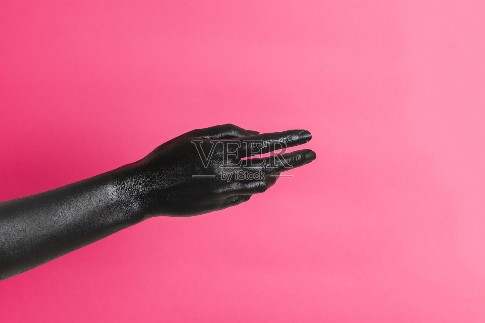 黑色涂漆的优雅女性手在粉色背景上手势表达。高端时尚艺术概念照片摄影图片