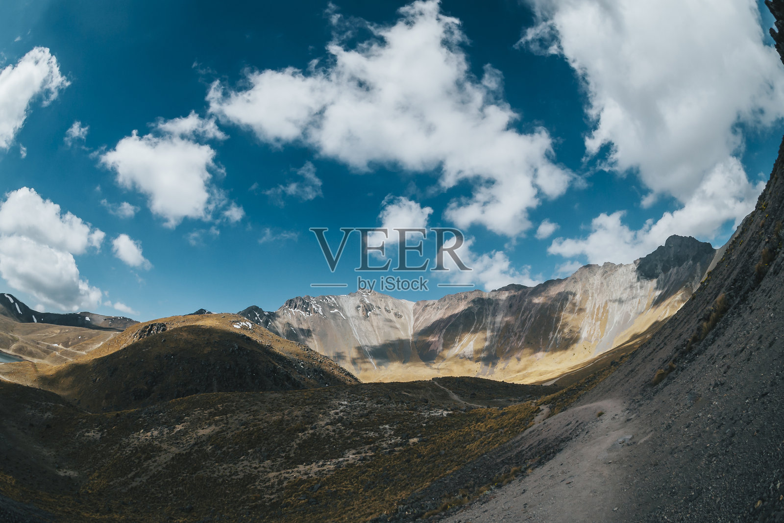 墨西哥托卢卡山的高山风景，可以看到火山口的边缘、美丽的绿松石色湖泊、山脊和蓝天中的云朵，以及草原。照片摄影图片