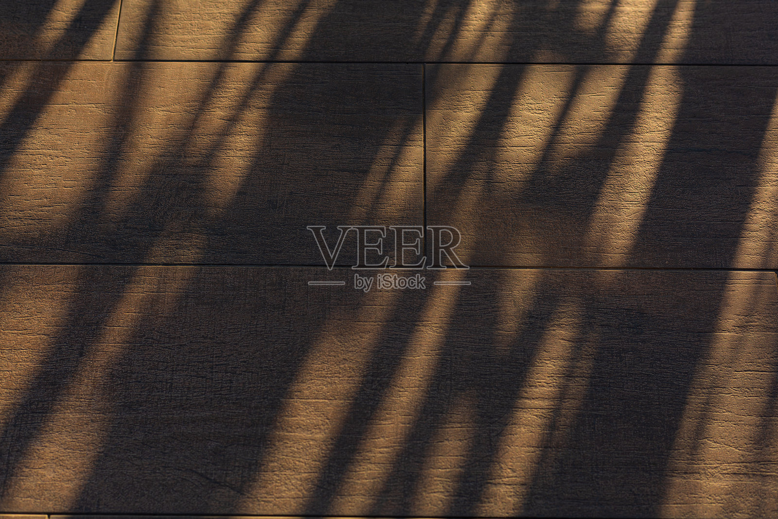 阳光影子的木地板背景，俯视柔和棕色桌子的高分辨率纹理和棕榈叶的阴影，夏季桌面背景，留有空白空间供文本或设计使用，柔和舒适的阳光桌面背景，无缝木纹。照片摄影图片