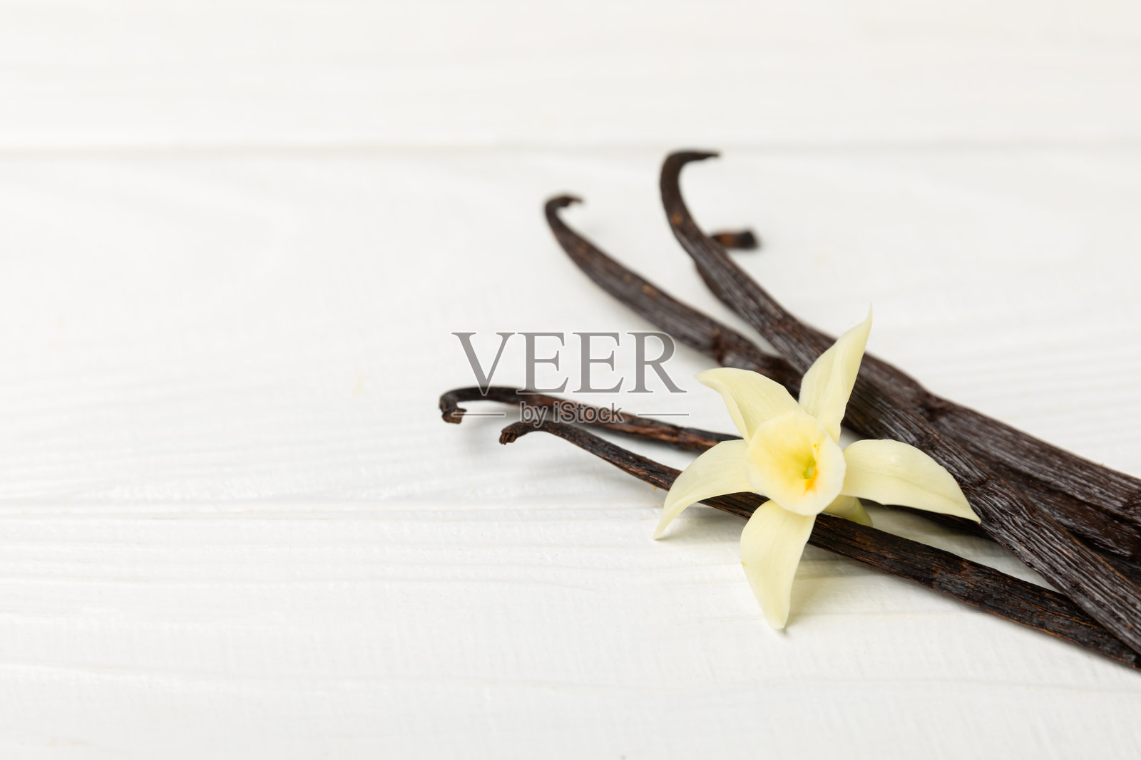 香草荚在有纹理的背景上。香草花和种子。香草棒。用于糕点和甜点的芳香香料。调味料。留白空间。照片摄影图片