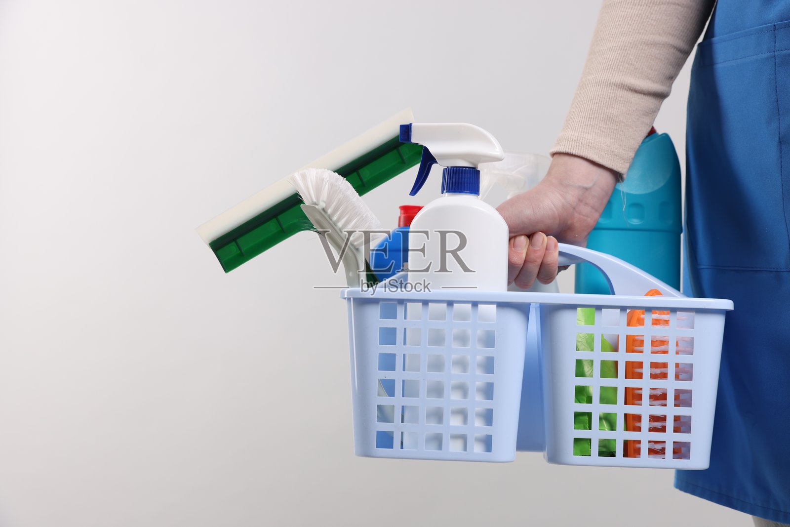 手持清洁用品篮子的女性，背景明亮，特写。留有文本空间。照片摄影图片