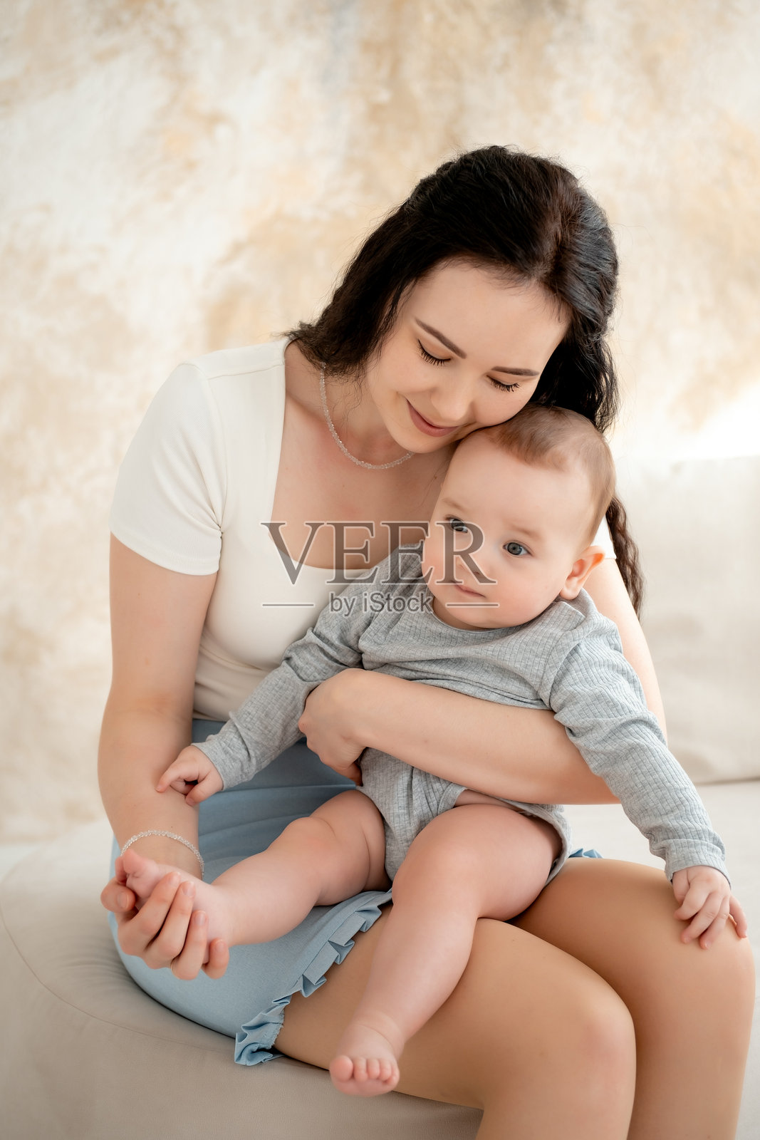 妈妈和宝宝，母亲拥抱并亲吻怀中的宝宝，母爱与关怀，年轻妈妈与宝宝一起玩耍，妈妈的命令照片摄影图片