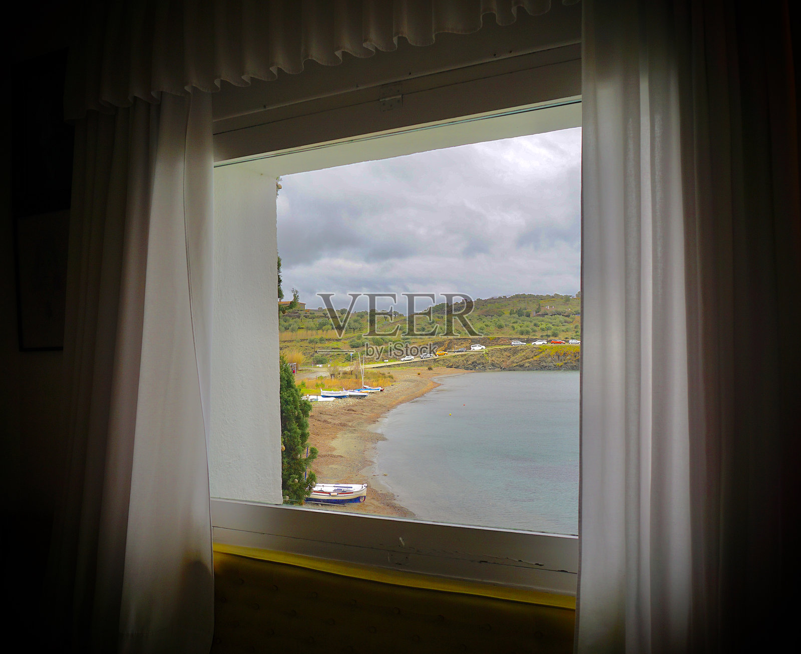 西班牙波特利加特。透过窗户看到的海滩景色。照片摄影图片