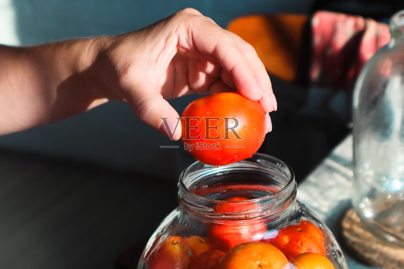 用罐子保存有机蔬菜。女人手中拿着一罐罐装番茄。可以罐装水果或蔬菜。照片摄影图片