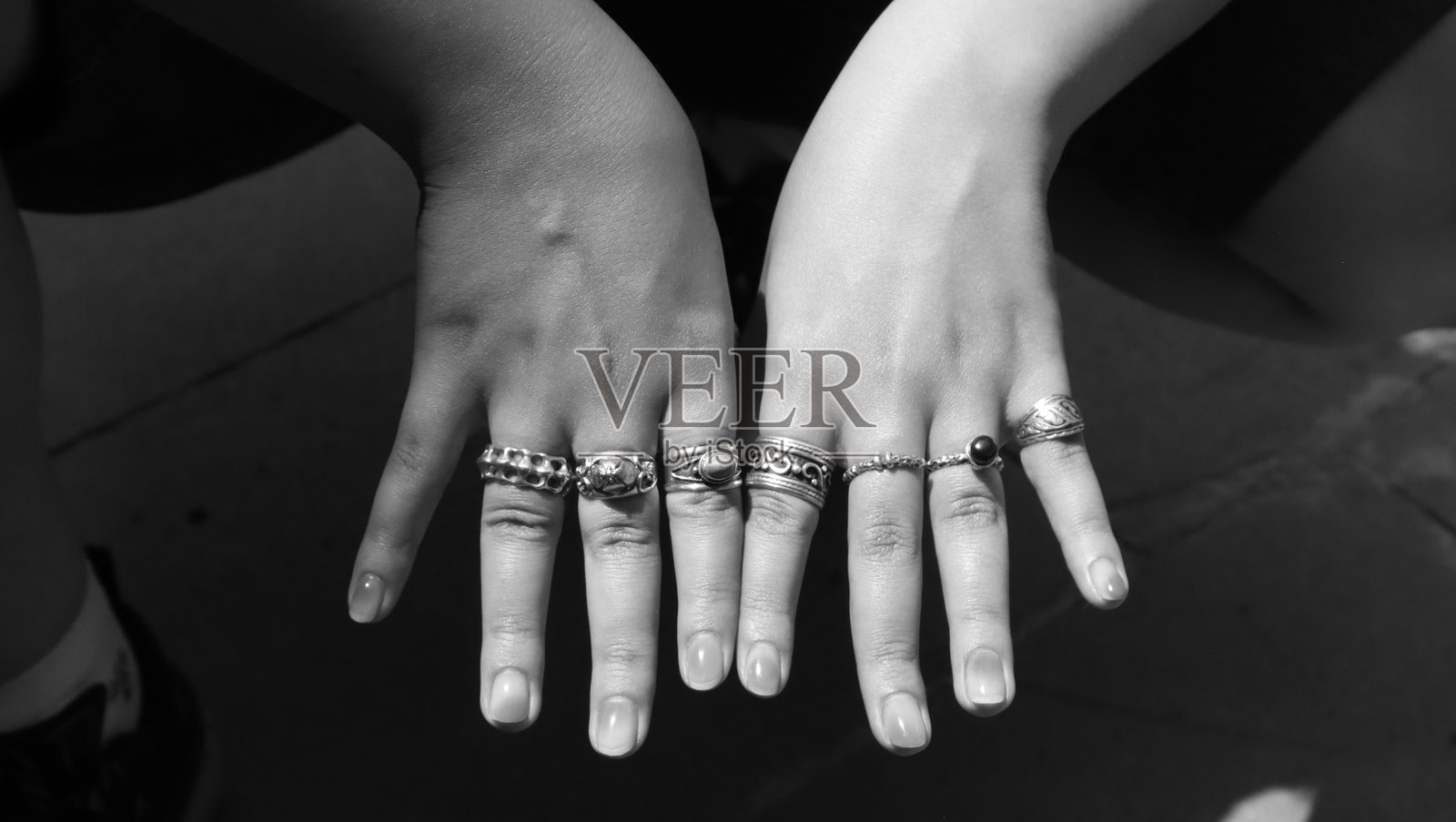 手中满是不同的银戒指照片摄影图片