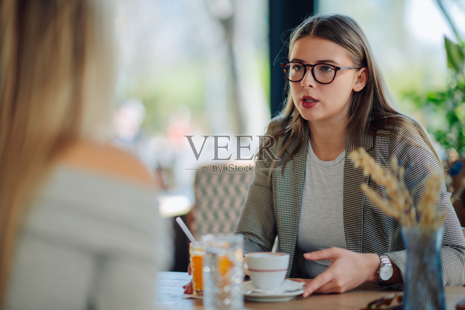 年轻女商人在咖啡馆与同事交谈照片摄影图片