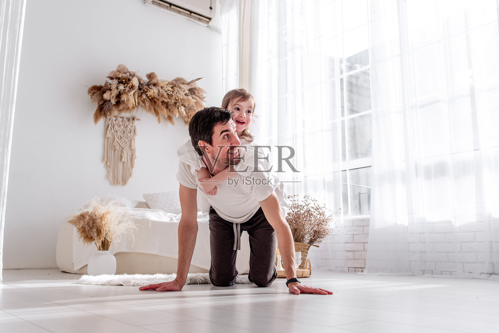 父亲和女儿在卧室地板上玩耍，享受珍贵的时光照片摄影图片