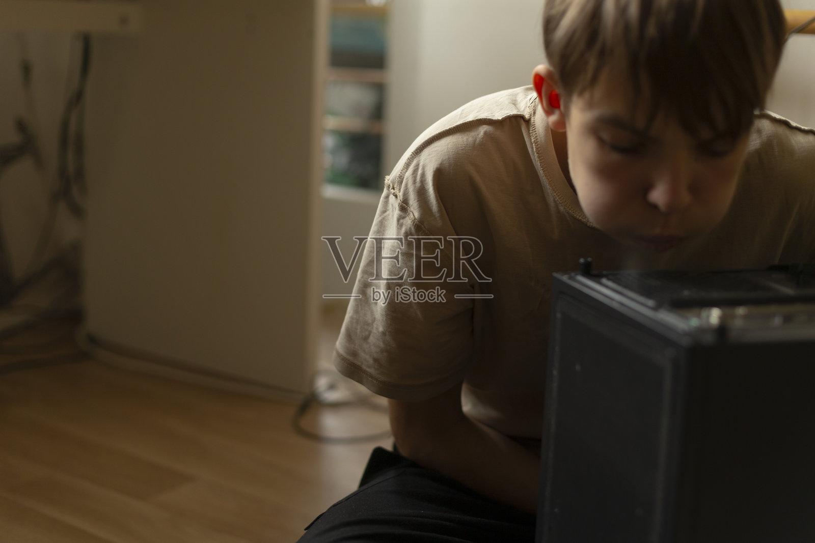 一个年轻男孩在安静的房间里与电子设备互动照片摄影图片