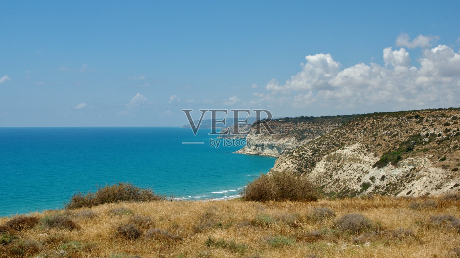阳光明媚的日子里，俯瞰碧蓝大海的海岸悬崖美景照片摄影图片