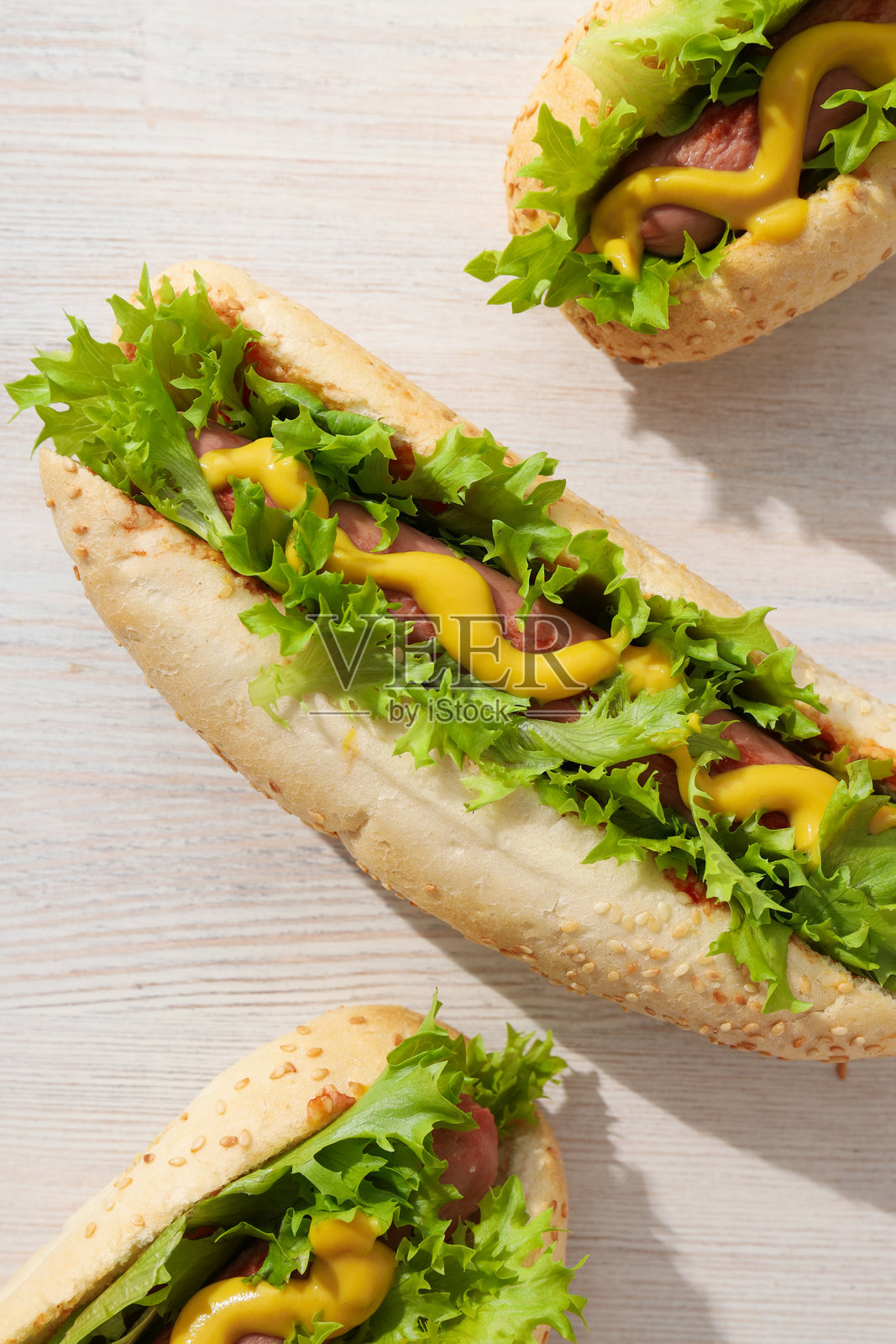 热狗配酱汁，放在浅色木质背景上，俯视图照片摄影图片