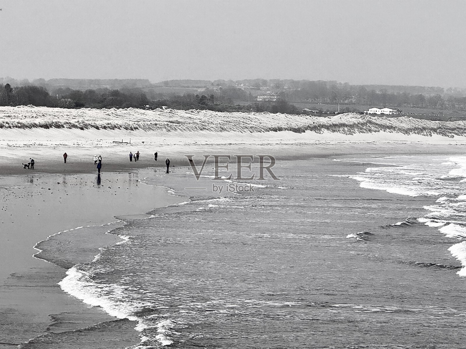 在诺森伯兰的安布尔海滩上行走的路人照片摄影图片