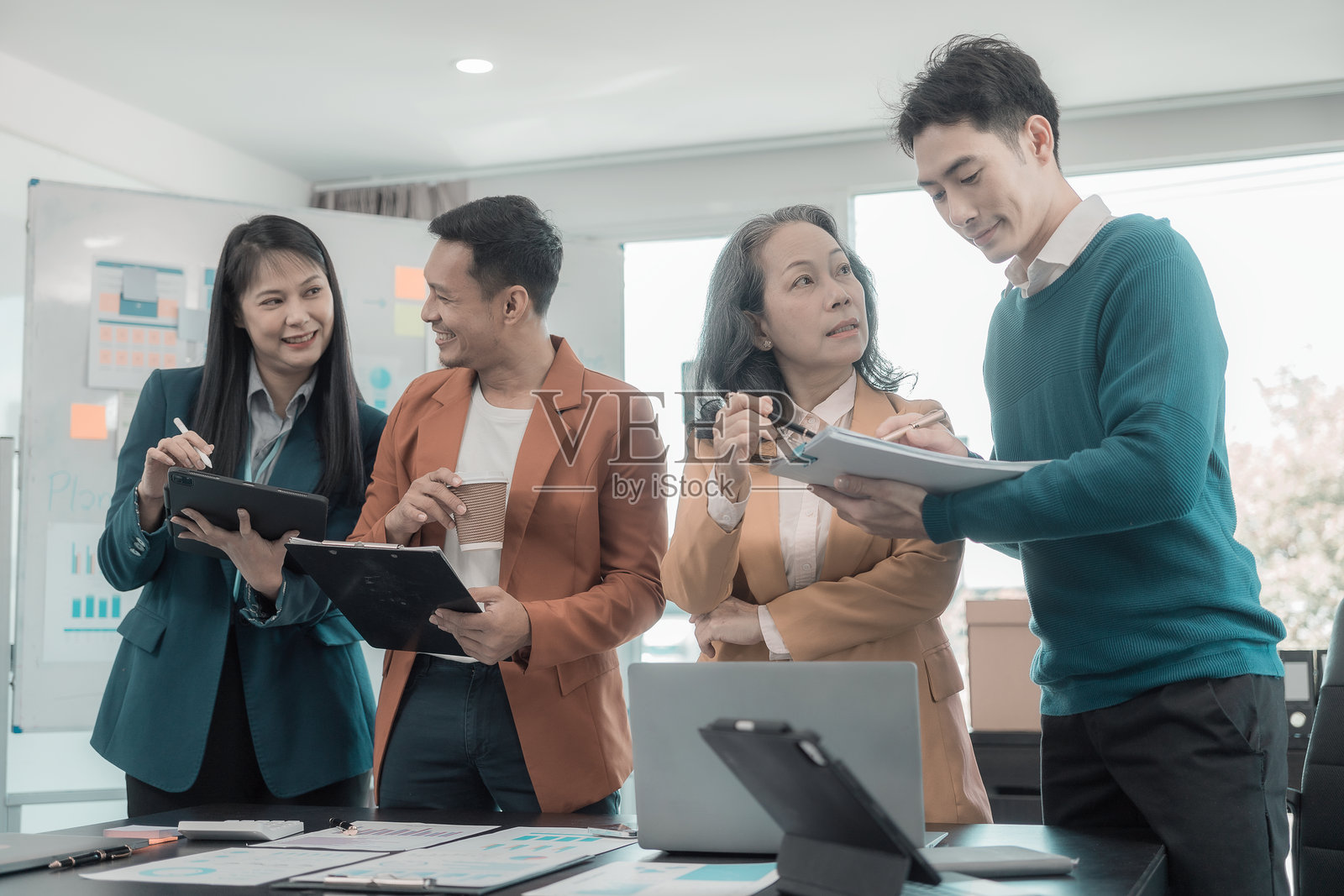 亚洲商业团队正在讨论显示成功团队合作成果的图表和图形，涉及投资和商业增长。照片摄影图片