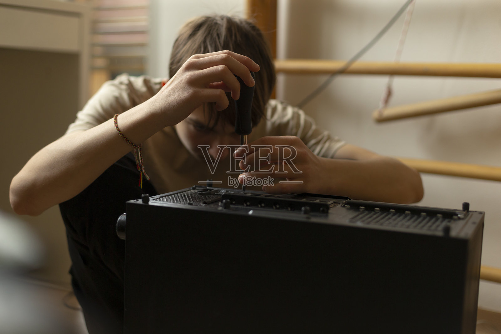 年轻技术人员在工作室环境中修理电子设备照片摄影图片