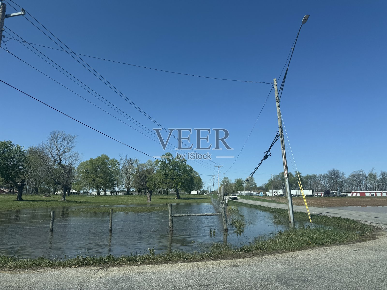 暴雨后被淹没的道路和倾斜的电线杆为驾驶者创造了危险的条件照片摄影图片