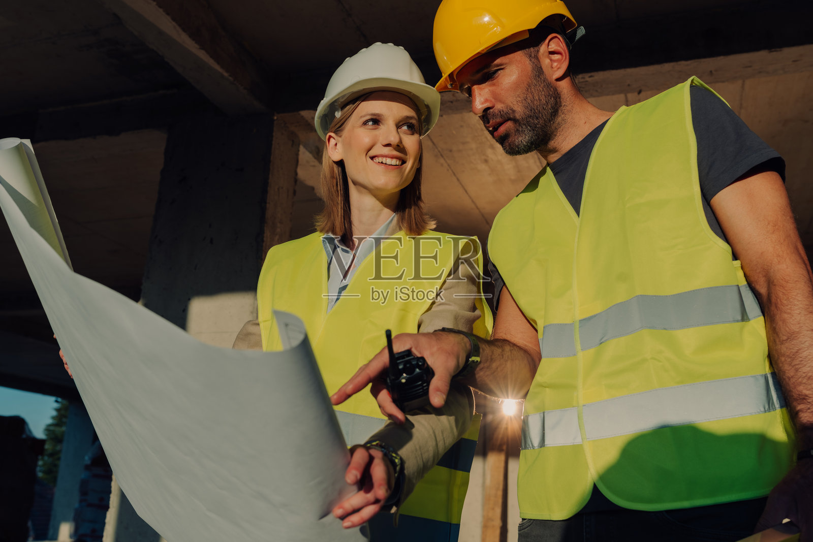 建筑工人在工地上查看蓝图照片摄影图片