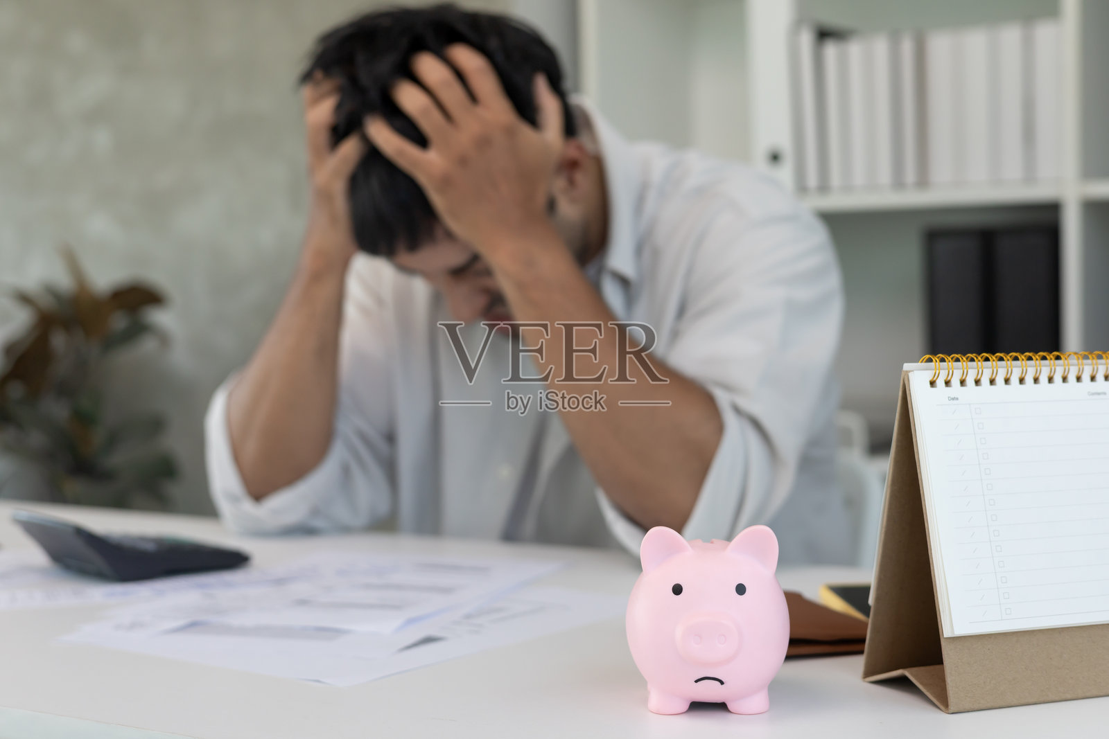 感到压力和头痛的亚洲男子，手中拿着大额账单或发票，无法支付费用和信用卡债务。财务短缺、经济问题、抵押贷款、贷款、破产、贫困、空钱包。照片摄影图片