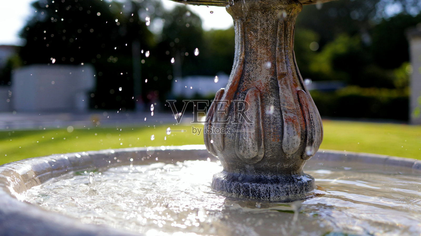 花园环境中的复古喷泉特写 – 经典装饰喷泉，流动水细节，位于宁静的城市公园或城市花园中照片摄影图片