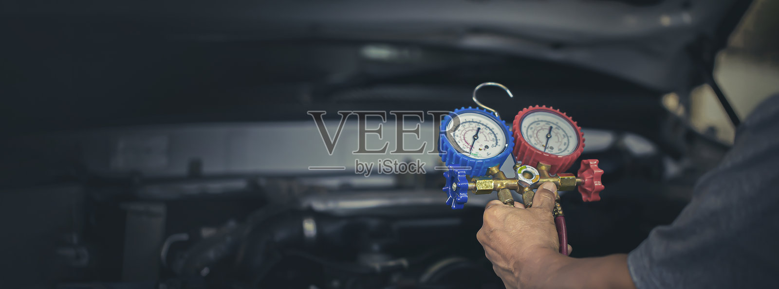 汽车维修工使用测量歧管表检查制冷剂照片摄影图片