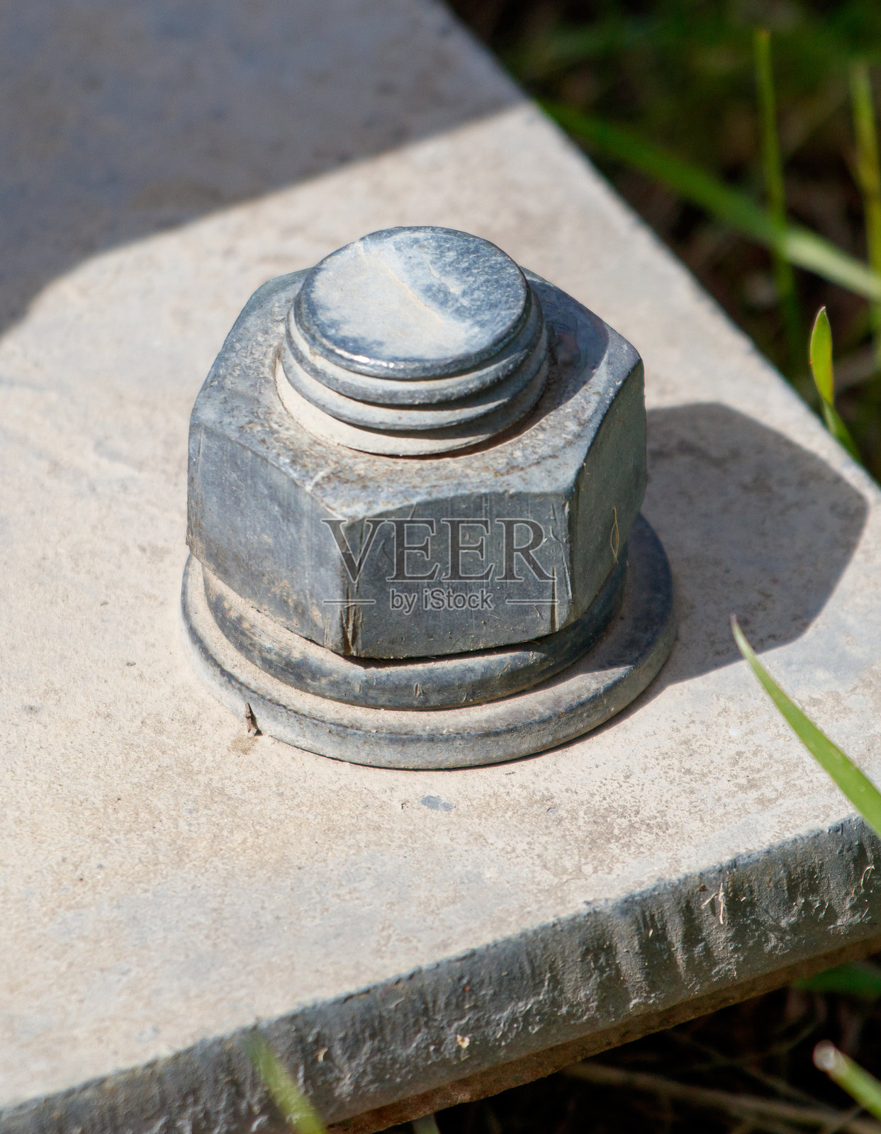 一个螺栓放在混凝土表面上照片摄影图片