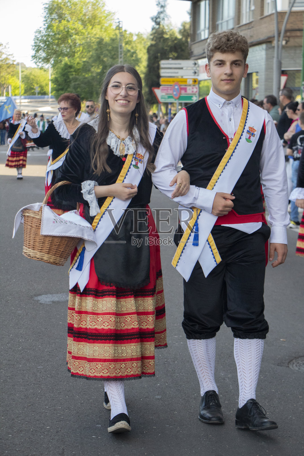 一对身着传统服饰的情侣手提装满甜点的篮子作为供品。照片摄影图片