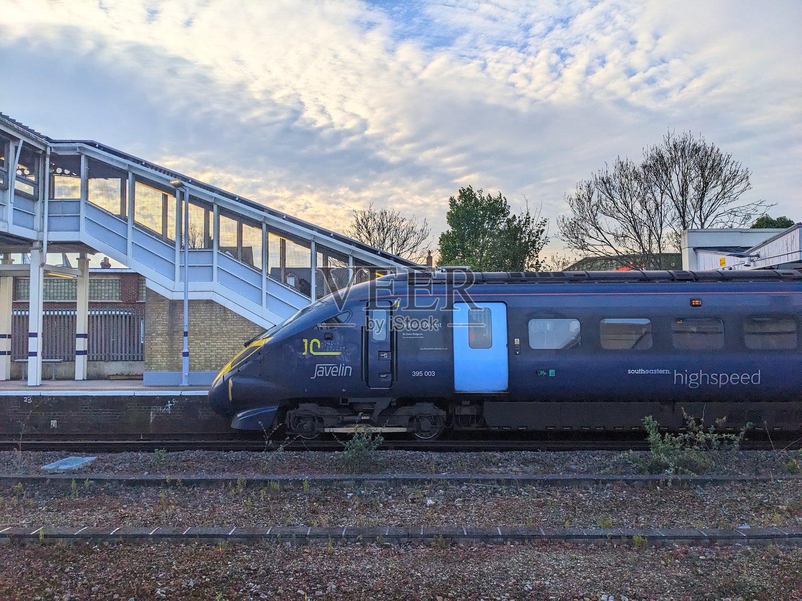 东南部高速箭头列车在坎特伯雷车站下的动态多云天空中照片摄影图片