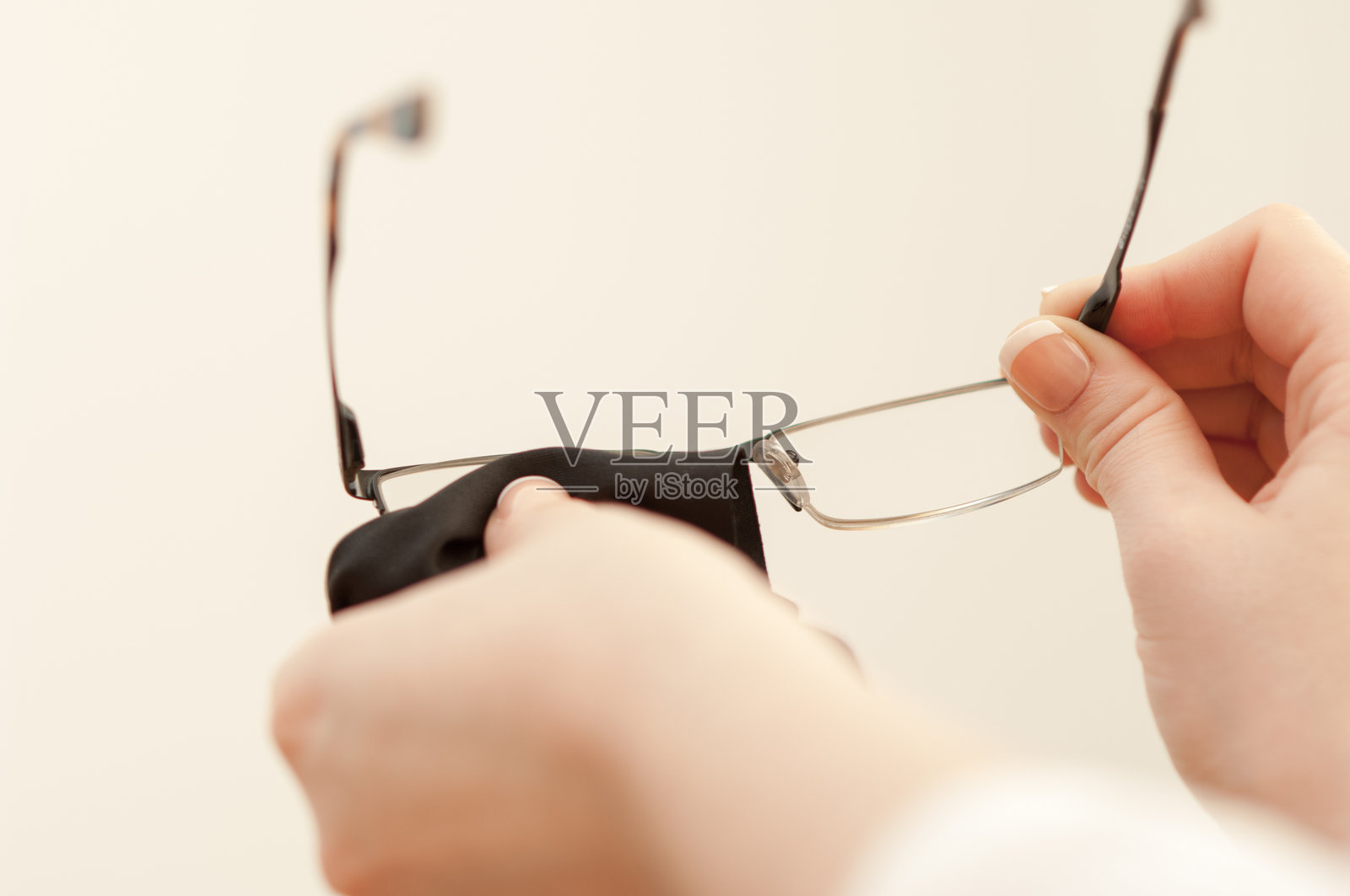 女人用超细纤维布清洁Vogue阅读眼镜照片摄影图片