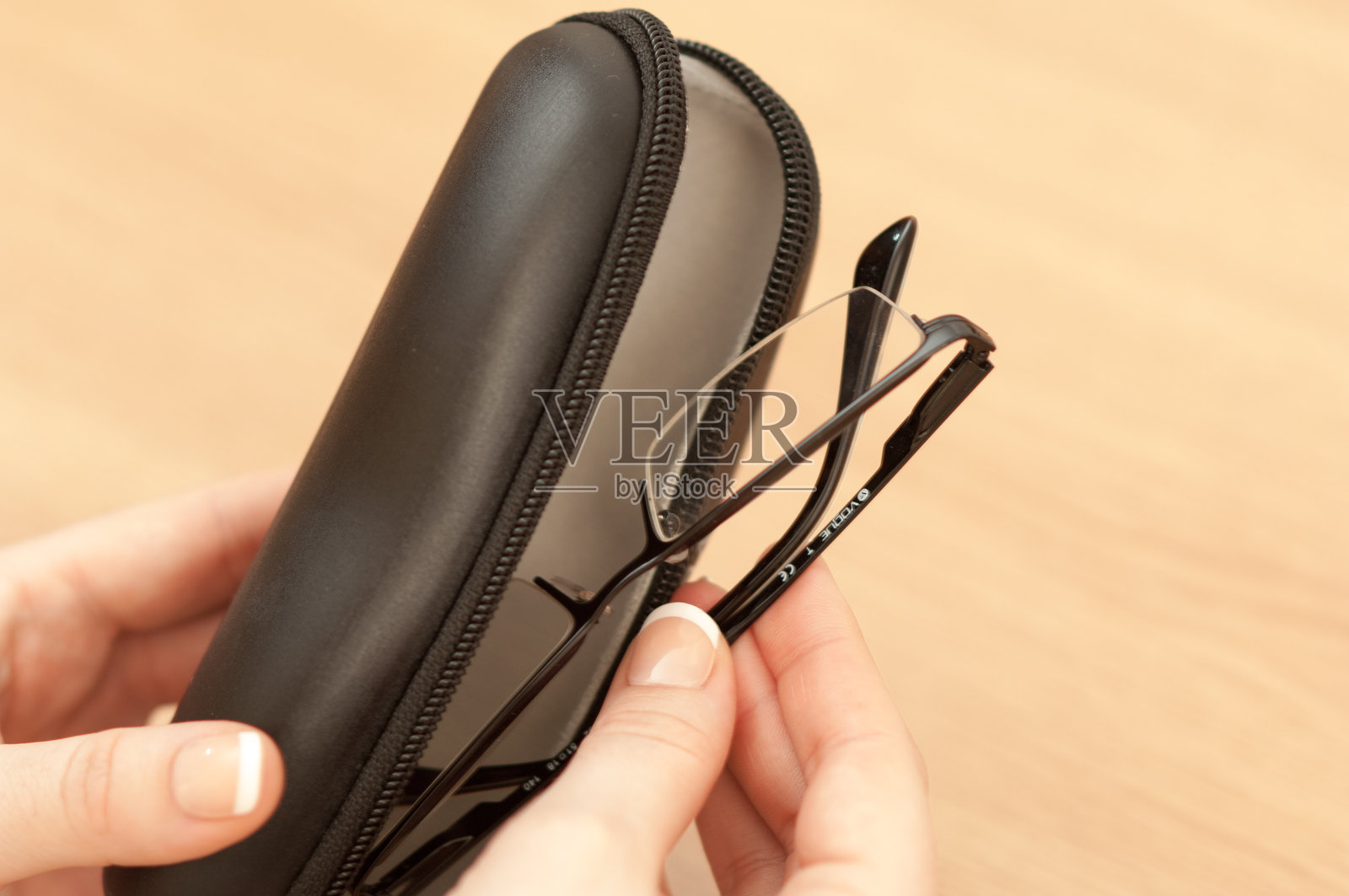 女人手持带有眼镜盒的Vogue阅读眼镜照片摄影图片