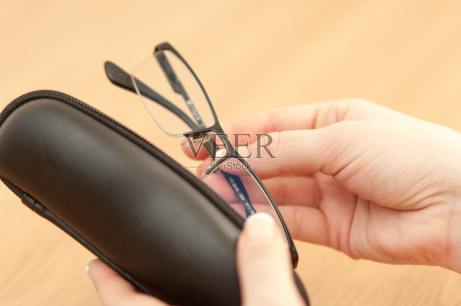 女人手持带有眼镜盒的Vogue阅读眼镜照片摄影图片