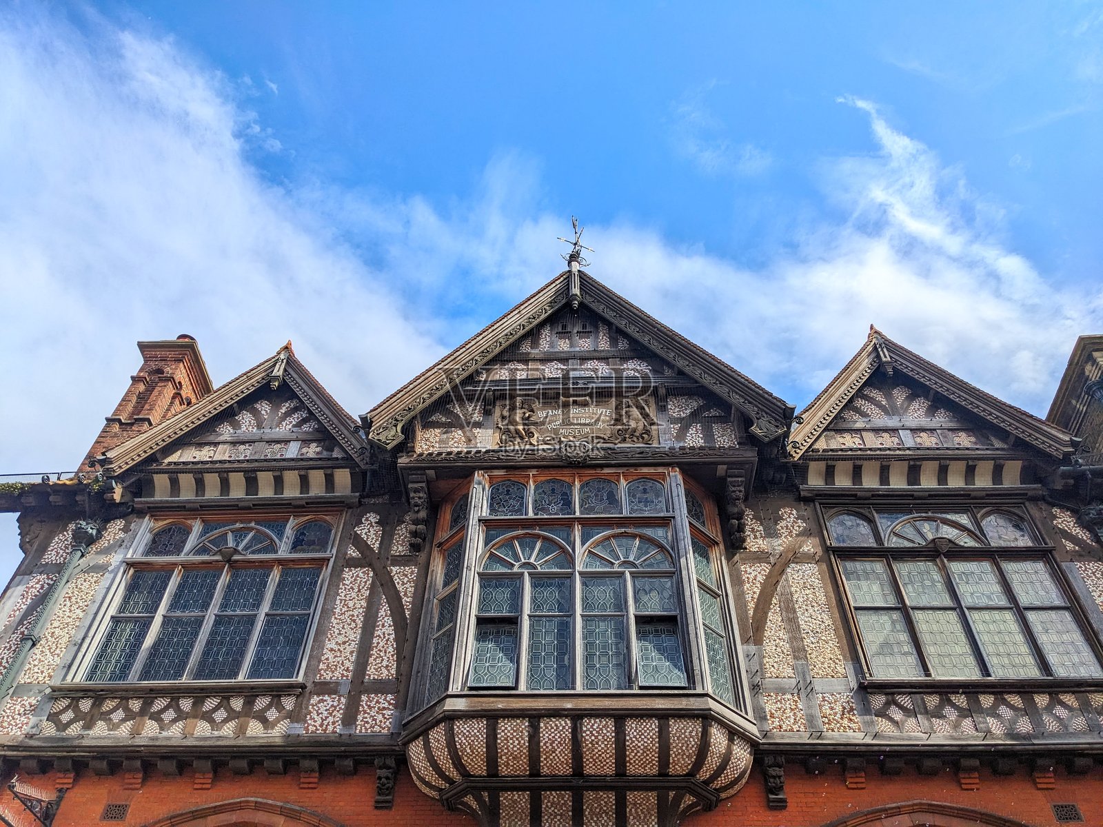 坎特伯雷历史悠久的比尼之家,复杂的木框架和燧石外立面在蓝天映衬下显得格外美丽。照片摄影图片