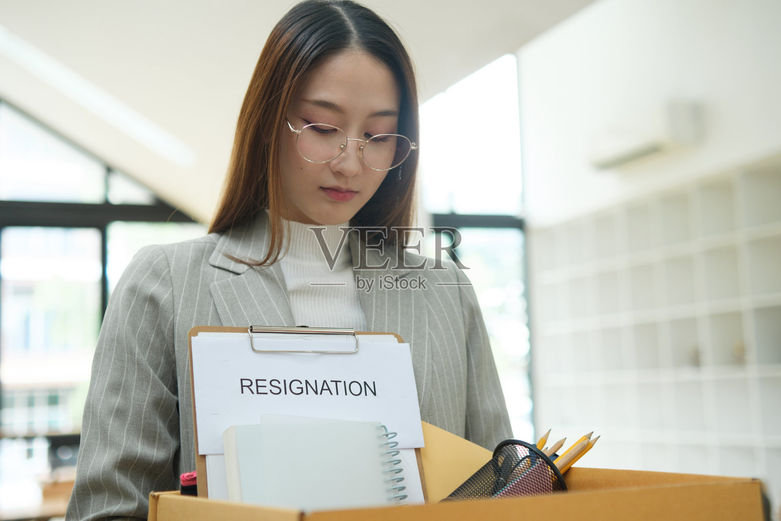 辞职概念。女商人正在打包个人物品，决定辞职、换工作或被公司解雇。照片摄影图片