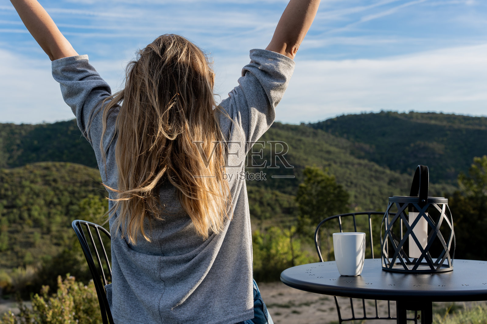 一位无法辨认的女性在户外喝咖啡，冥想并享受风景和新鲜空气，度假时光。照片摄影图片