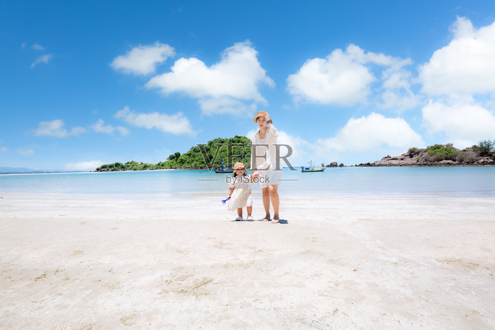 一位母亲和她的小女儿在热带海滩上散步照片摄影图片