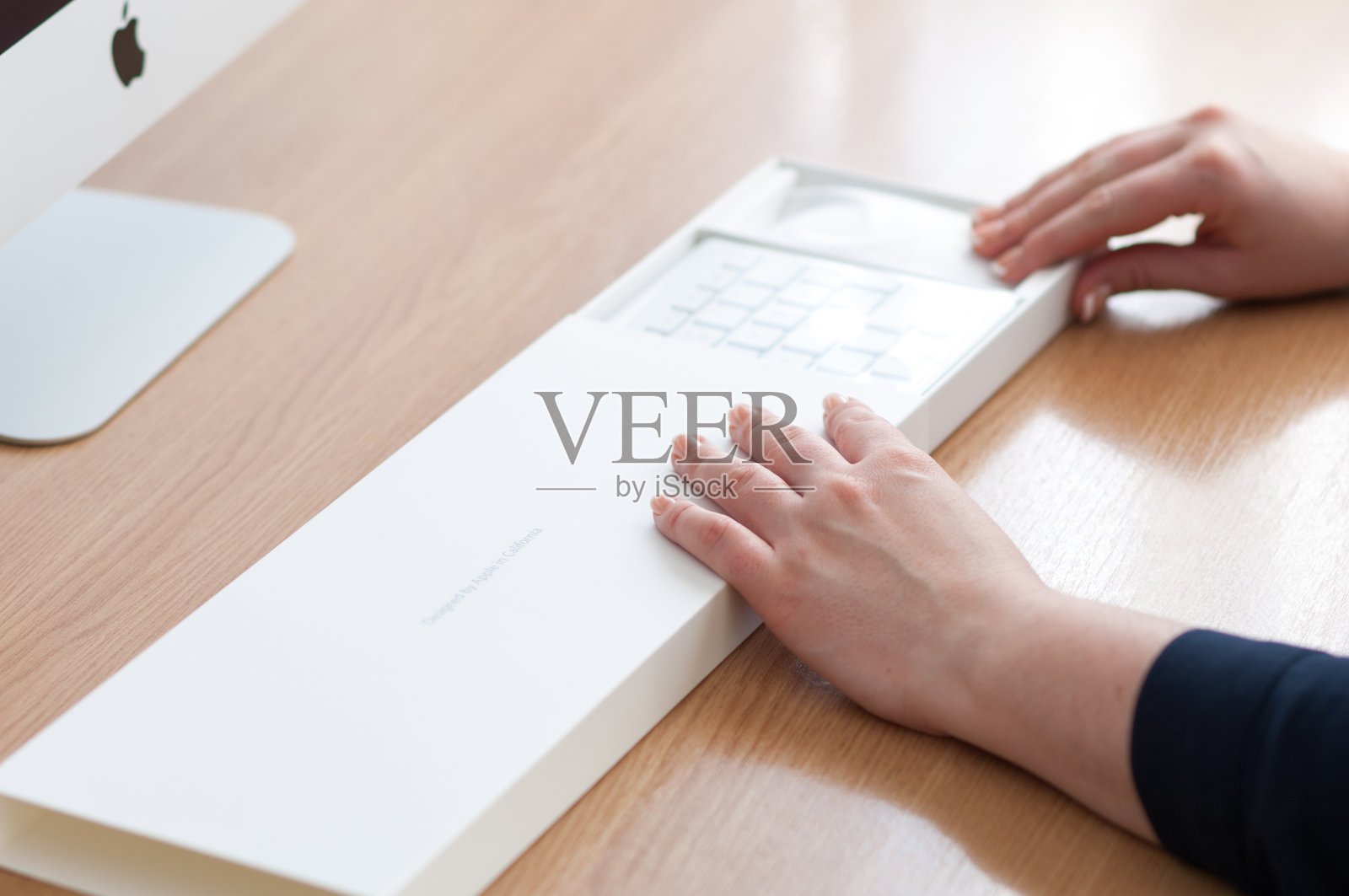 女人正在拆包新的苹果无线键盘和鼠标照片摄影图片