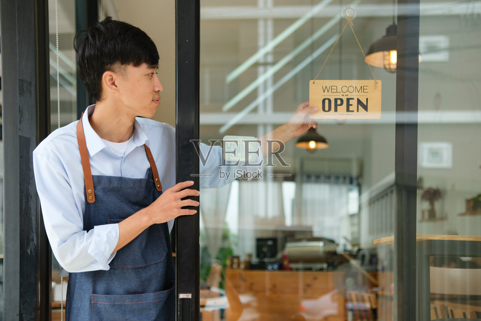 小企业主开店迎接顾客照片摄影图片