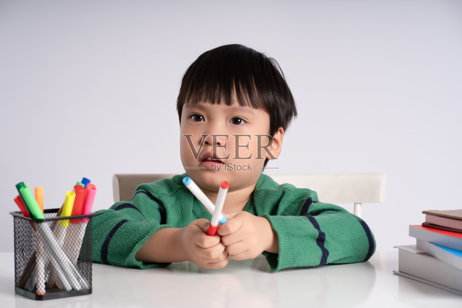 一名亚洲男孩在白色背景下学习的肖像照片摄影图片