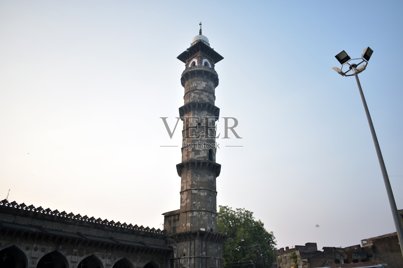 布尔汉普尔市展示了一座古老的宣礼塔，直指天空，周围是宁静的傍晚氛围和柔和的光线。照片摄影图片