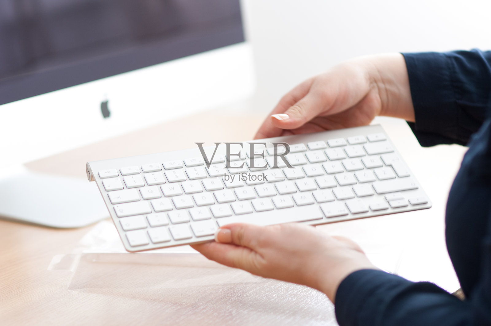 女人正在拆包新的苹果无线键盘照片摄影图片