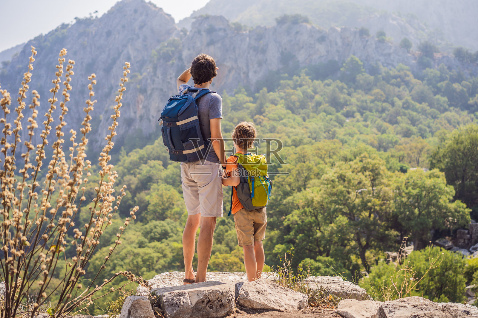父子游客探索特尔梅索斯古城的壮观古剧场。与孩子们一起旅行的概念。土耳其，走遍各地。照片摄影图片