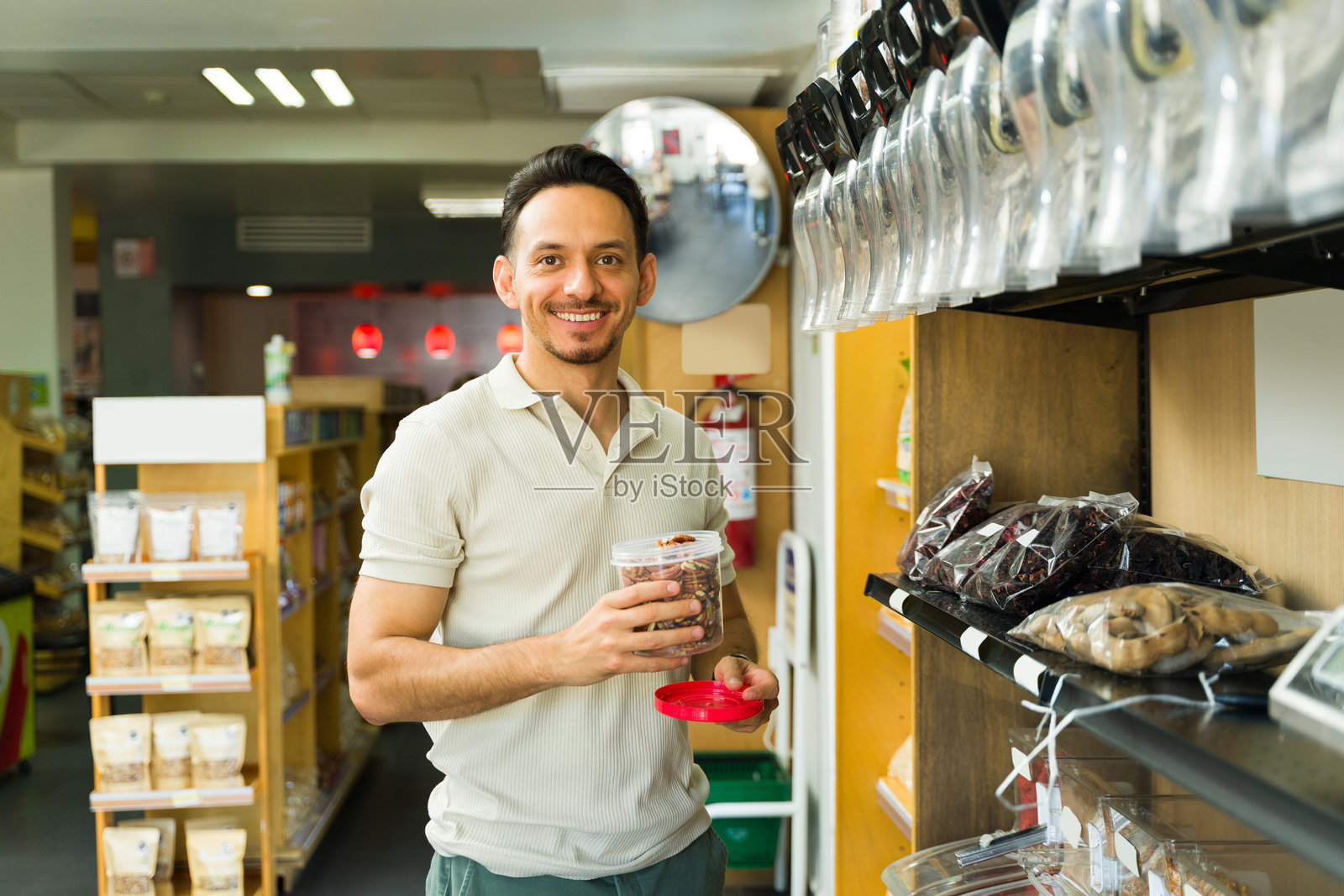 西班牙裔男子在散装食品店挑选坚果照片摄影图片