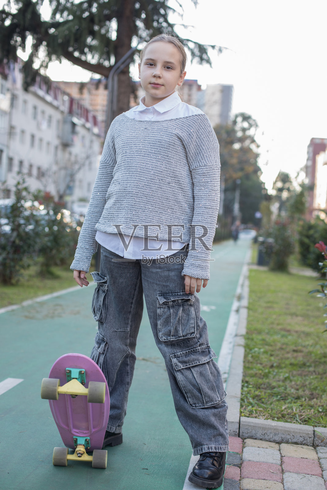 快乐的孩子滑板者，女孩微笑着在户外玩滑板或享受骑行乐趣照片摄影图片