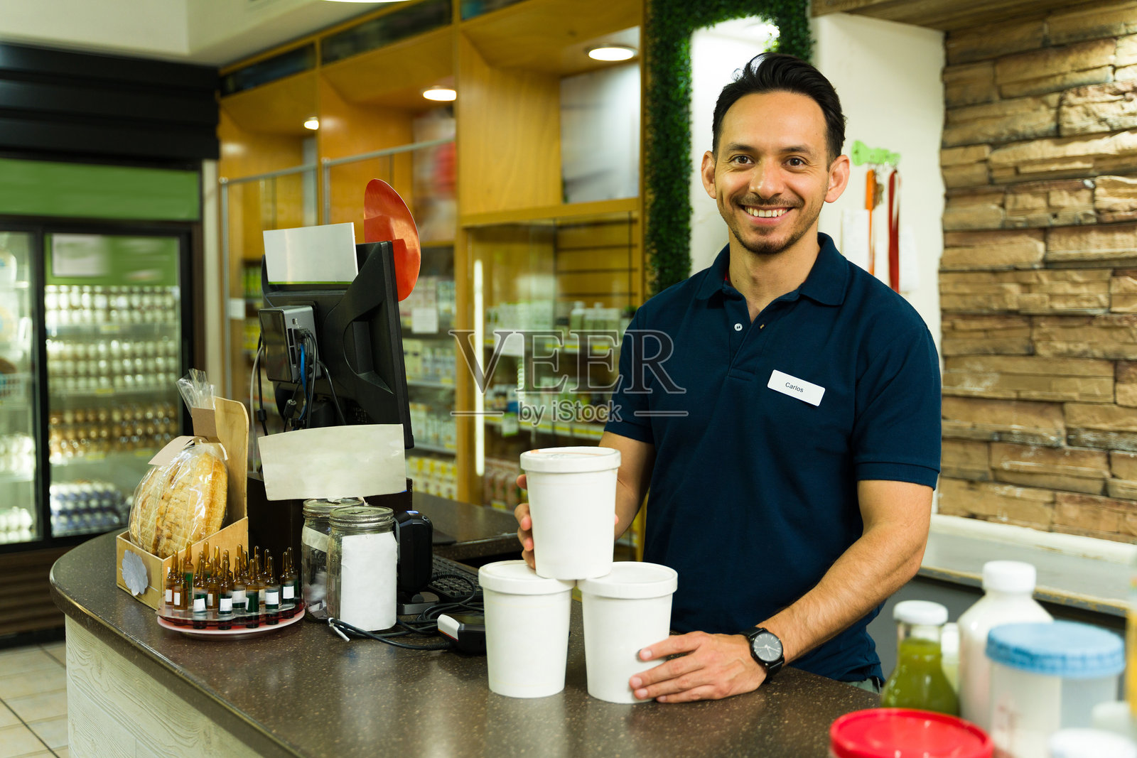 微笑的店员在杂货店的收银台上拿着外卖食品容器照片摄影图片