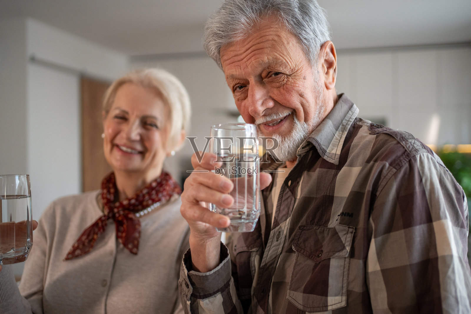 快乐的老年夫妇在家中一起喝新鲜水照片摄影图片